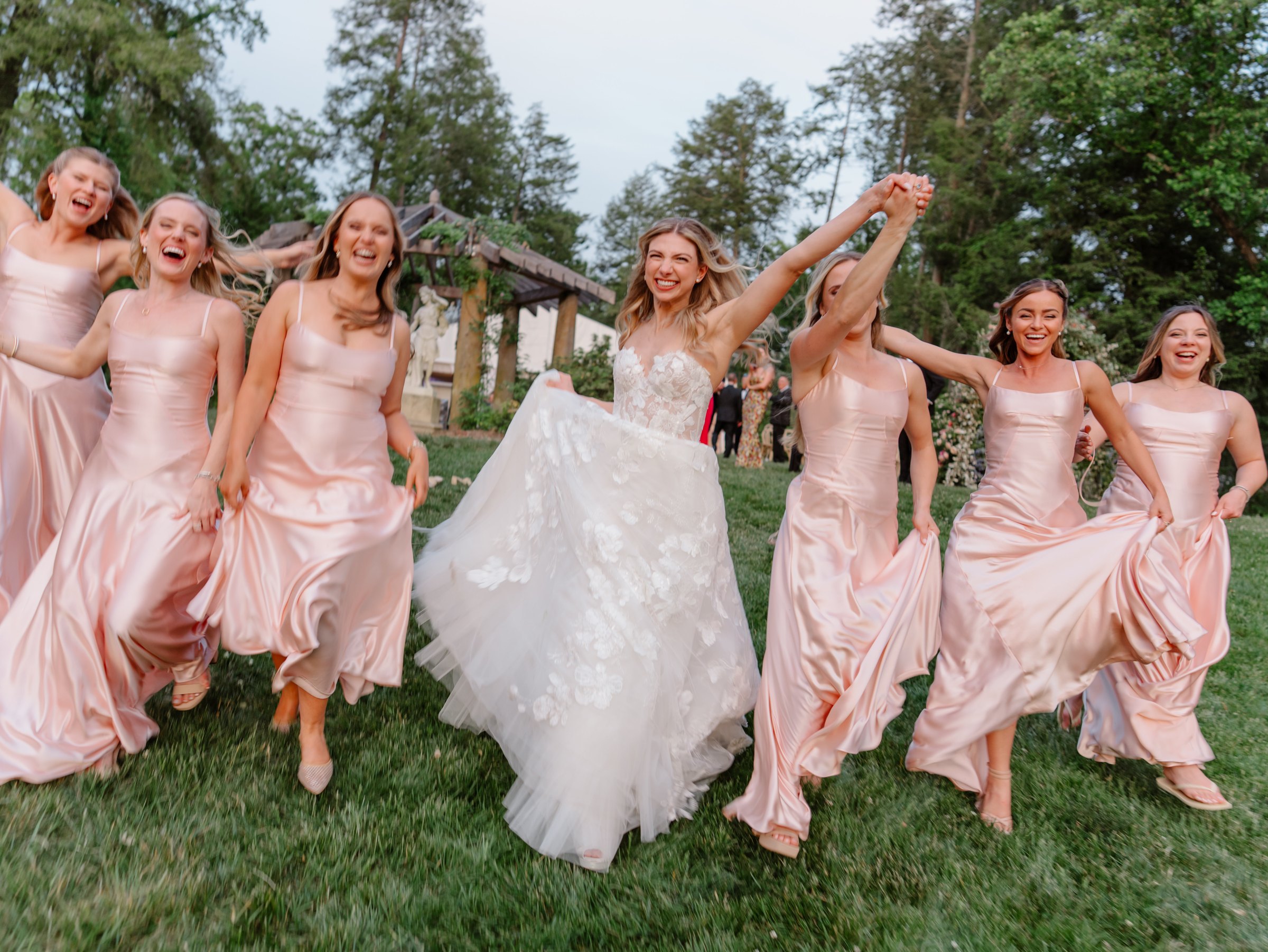 Lauren and her bridesmaids running across the lawn at the Biltmore