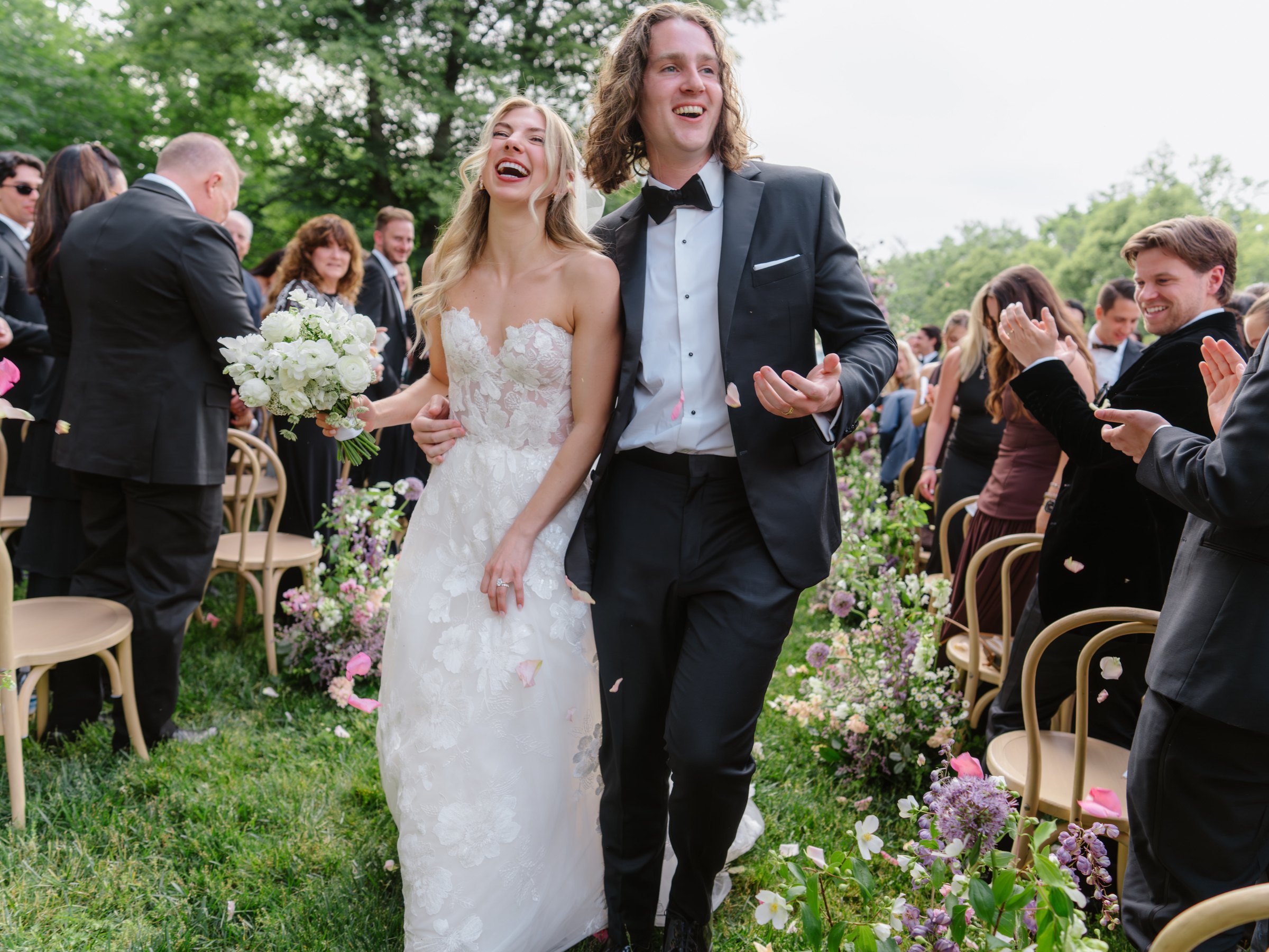 Lauren and Daniel walking up the aisle through their guests at the Biltmore Estate