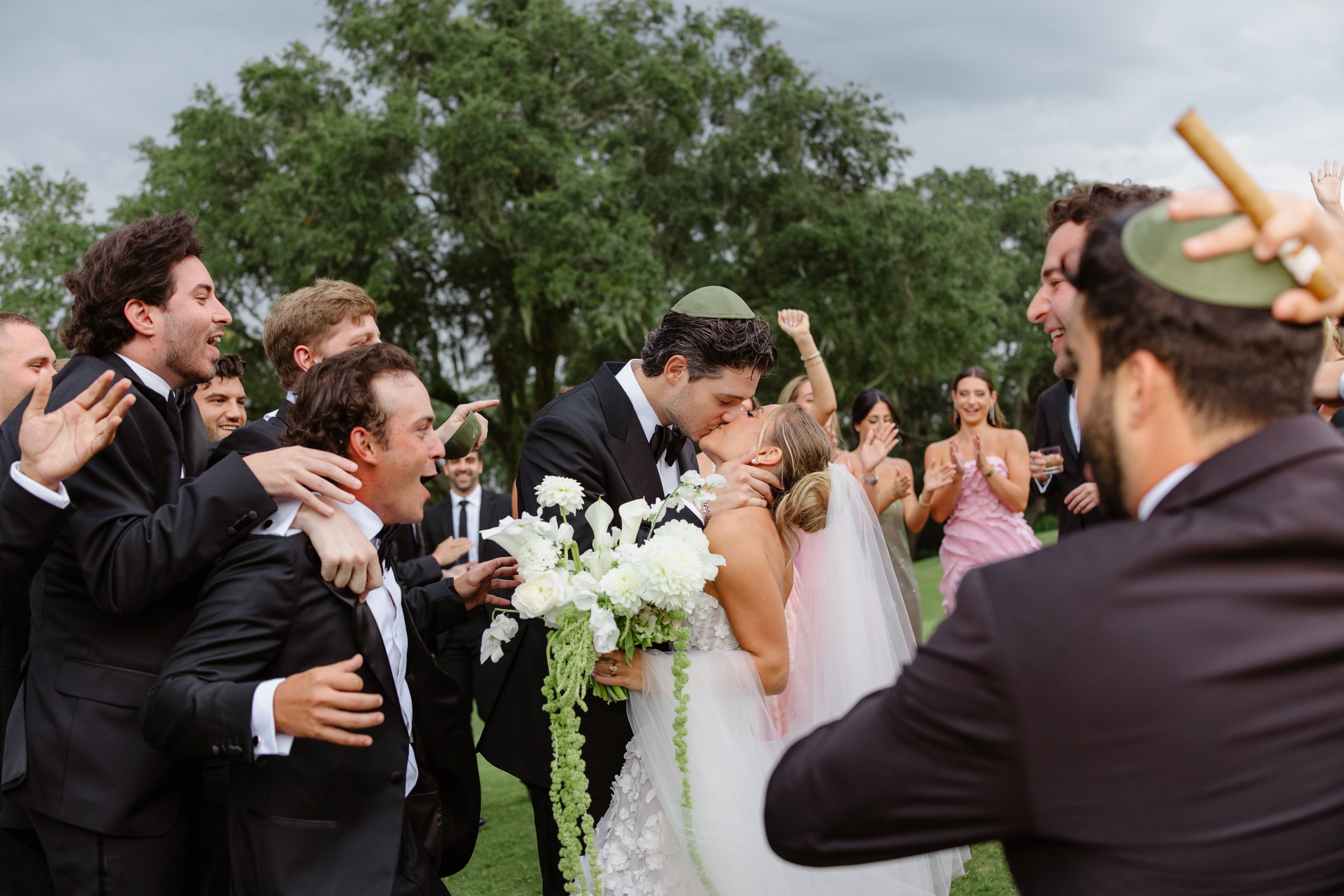 Paige & Jake’s first kiss as the wedding party erupts — a Charleston wedding by Mia Melin